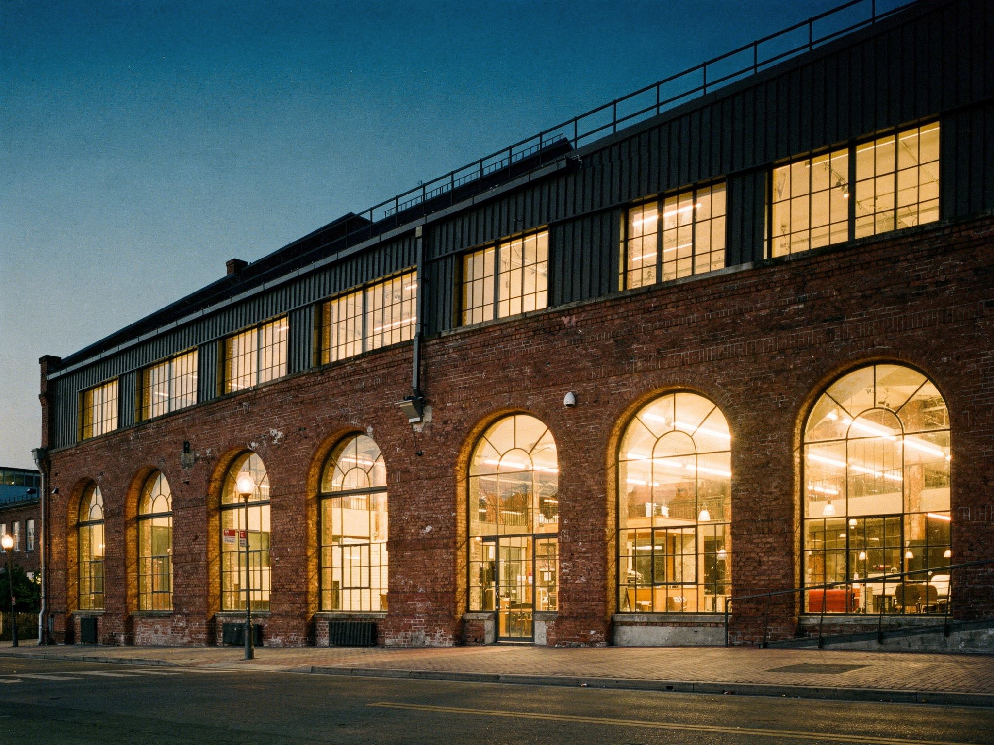 The warehouse facade glowing warm at dusk