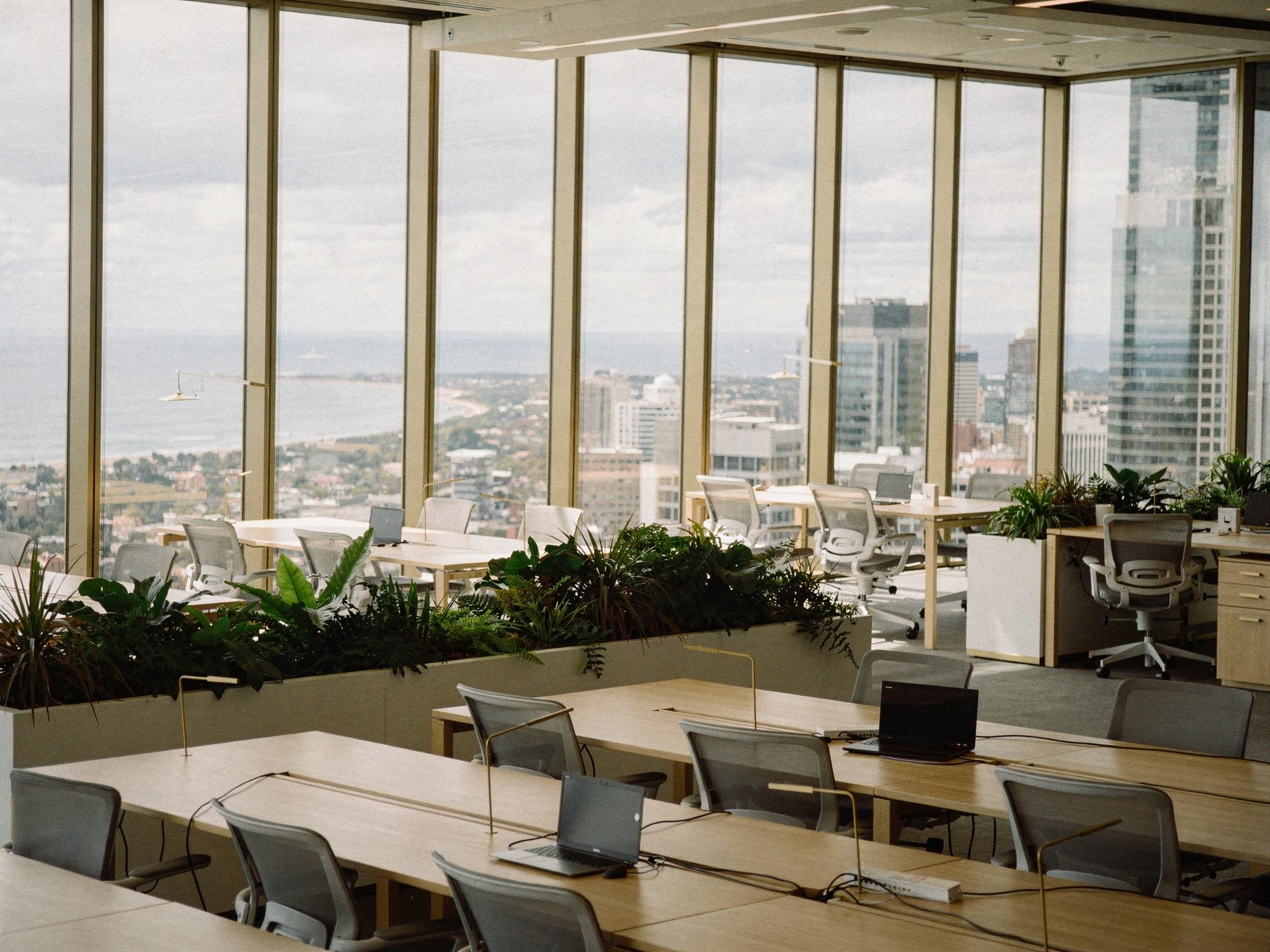 An open-plan office floor with bronze-mullioned glazing over the city