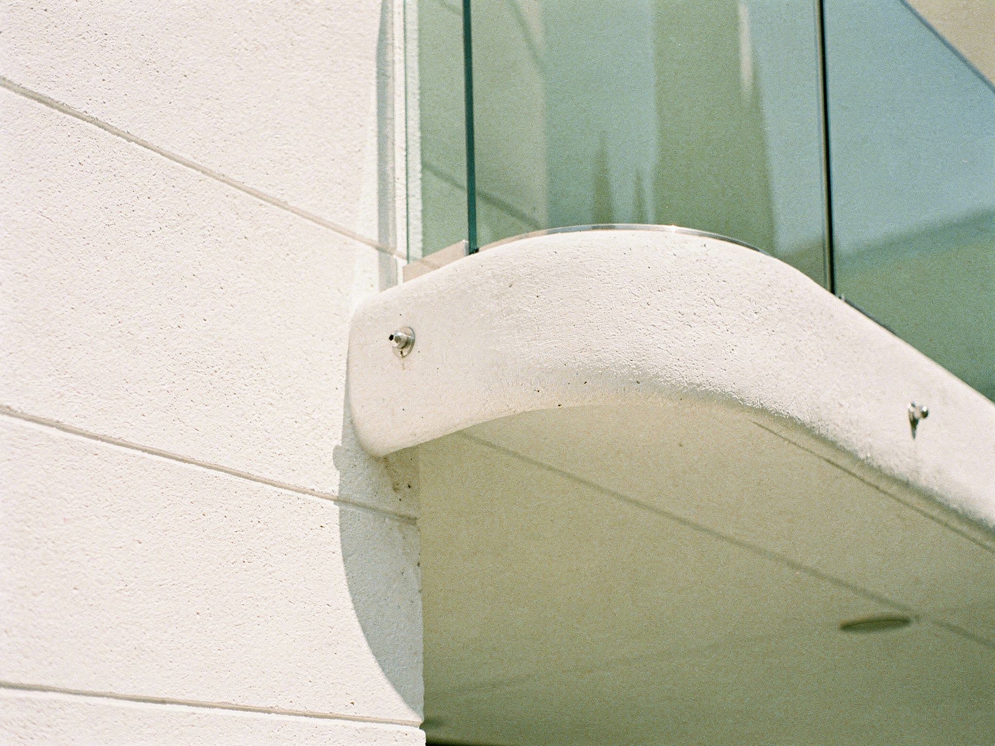 GRC balcony edge meeting glass balustrade, macro construction detail