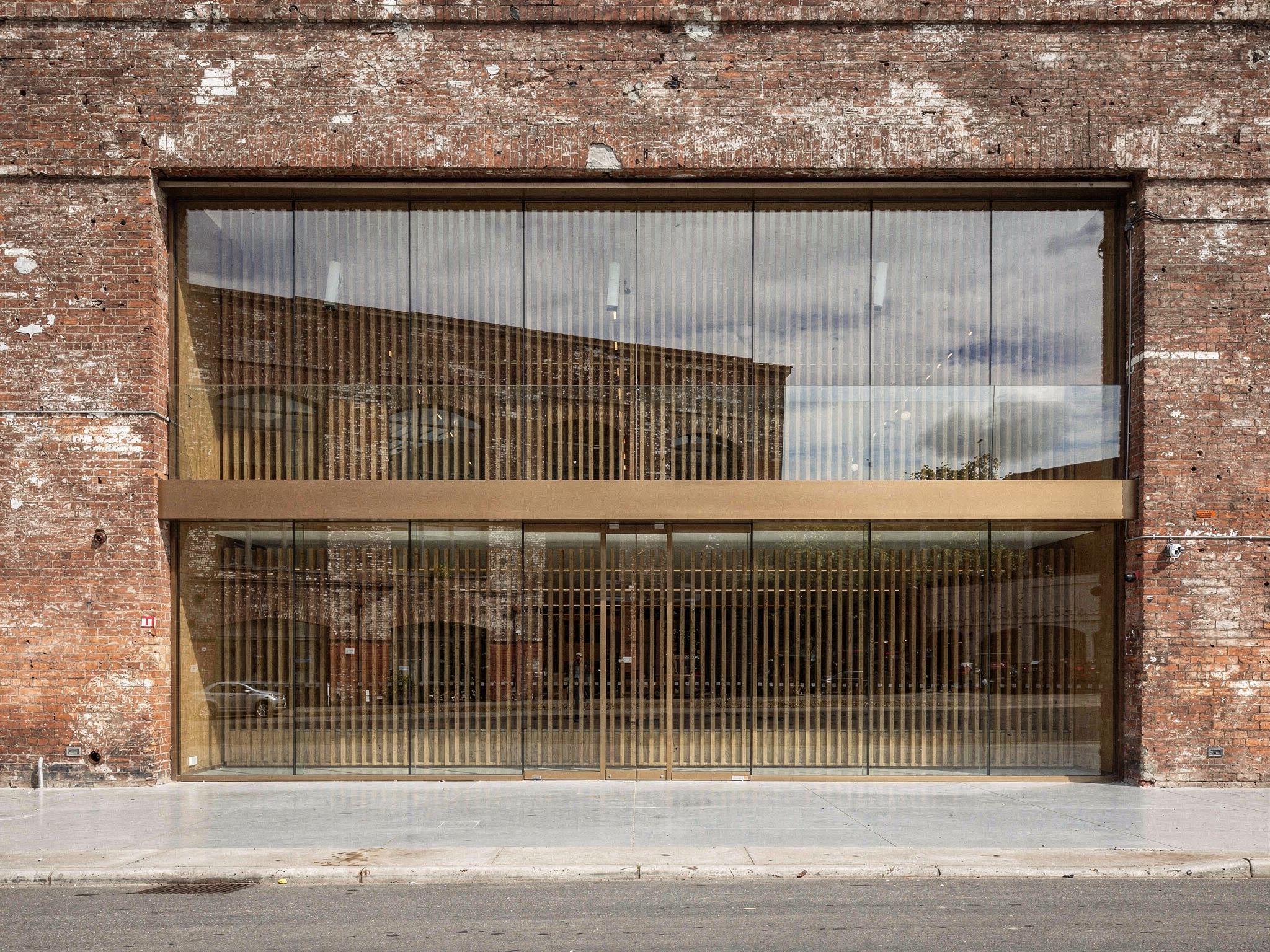 Deadpan elevation showing new steel and glass shopfronts set into the original brick openings